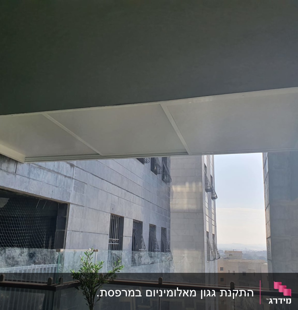 גג אלומיניום מעל מרפסת עם מעקה זכוכית